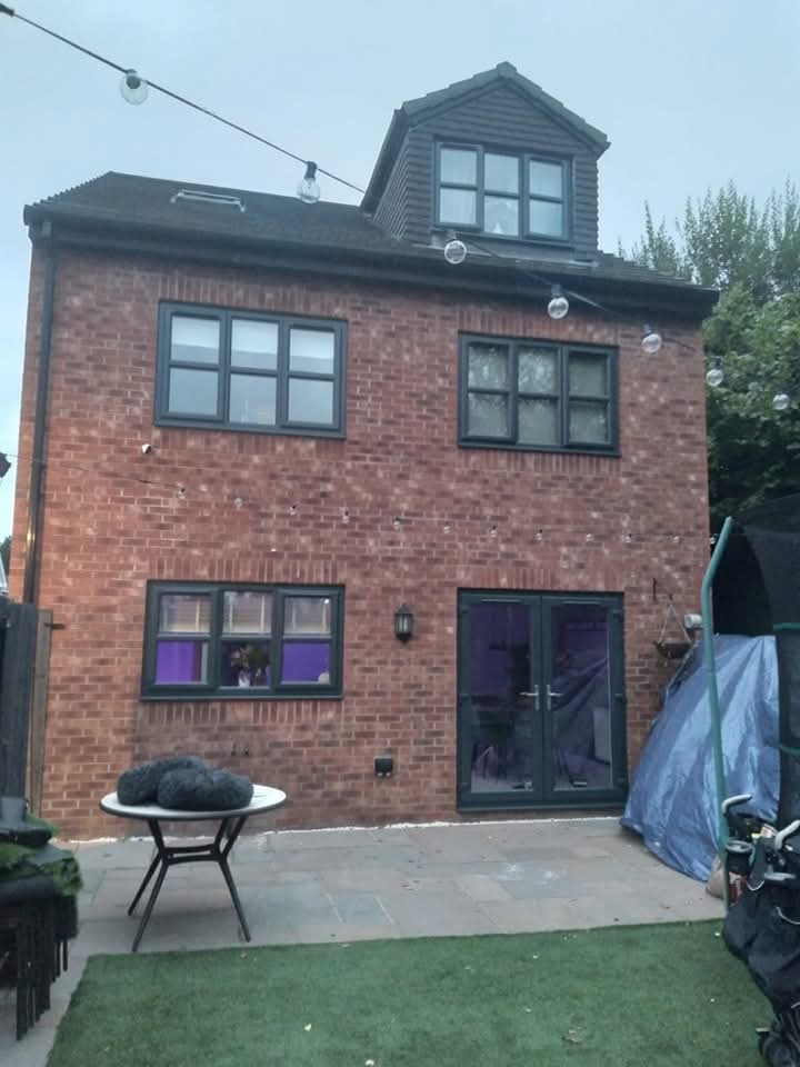 Red brick house with anthracite grey sprayed uPVC windows and patio doors