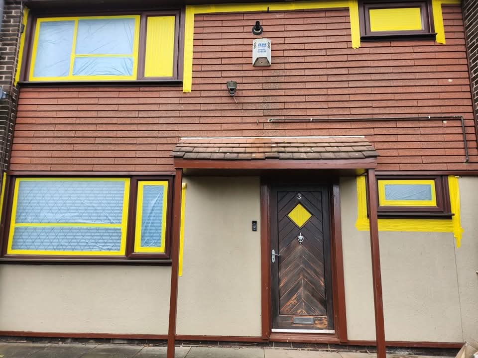 House front with windows and door masked ready for uPVC spraying